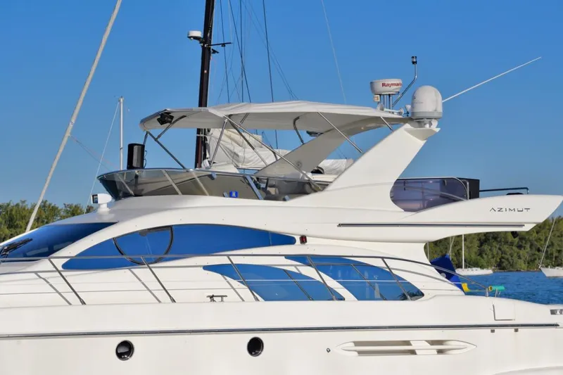 Slide: The Image of 2006 Azimut Fly yacht with sleek design, docked under clear blue sky. - 20