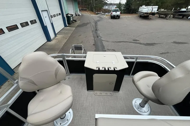 Slide: The Image of 2026 Avalon VTX Quad Fish boat interior with beige seats and storage compartment. - 15