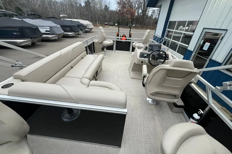 Slide: The Image of 2026 Avalon VTX Quad Fish pontoon boat interior with beige seating and steering console. - 17