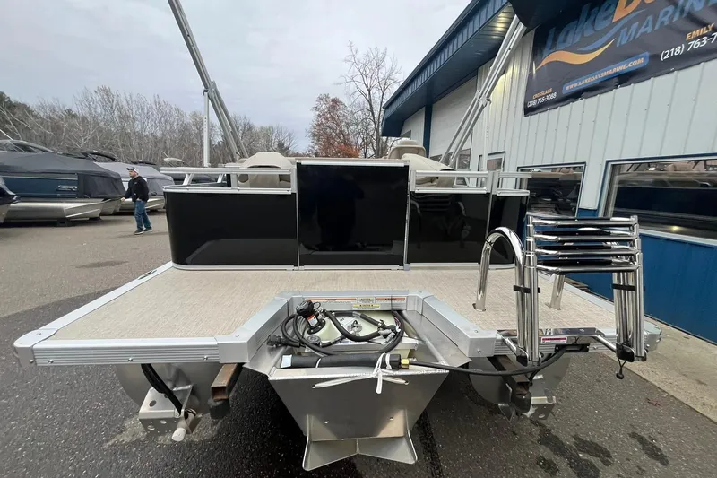 Slide: The Image of 2026 Avalon VTX Quad Fish pontoon boat at marina, rear view with ladder and engine. - 3