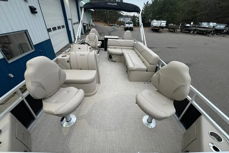 Slide: The Image of 2026 Avalon VTX Quad Fish pontoon boat with beige seating and spacious deck layout. - 8