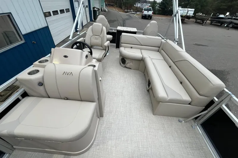Slide: The Image of 2026 Avalon VTX Quad Fish boat interior with beige seating and steering console. - 9