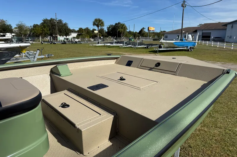 Slide: The Image of 2025 SeaArk Phantom 20XV boat deck with storage compartments, parked outdoors. - 5