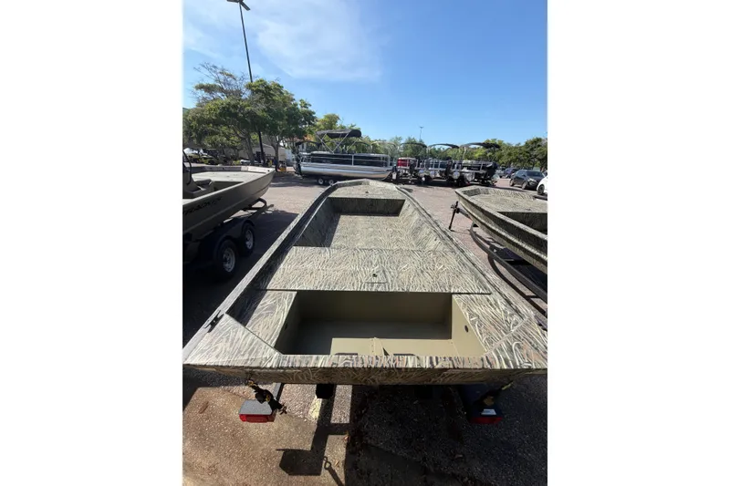 Slide: The Image of 2026 Tracker Grizzly 1648 Utility boat in parking lot, showcasing camouflage design. - 2