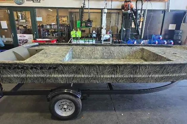 Slide: The Image of 2026 Tracker Grizzly 1648 Utility boat on trailer in a workshop setting. - 6