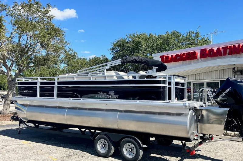 Slide: The Image of 2026 Sun Tracker Fishin' Barge 22 XP3 pontoon boat at dealership, sunny day. - 8