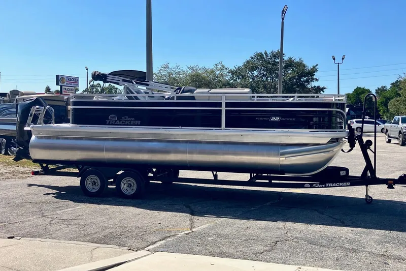 Slide: The Image of 2026 Sun Tracker Fishin' Barge 22 XP3 pontoon boat on trailer in parking lot. - 83