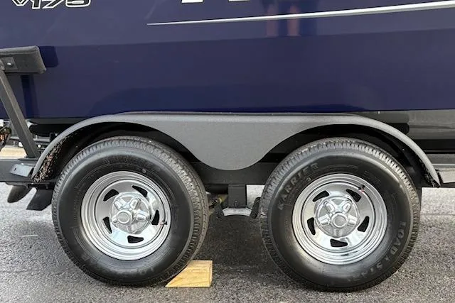 Slide: The Image of 2026 Tracker Pro Guide V-175 WT trailer wheels on pavement, showcasing dual tire setup. - 79
