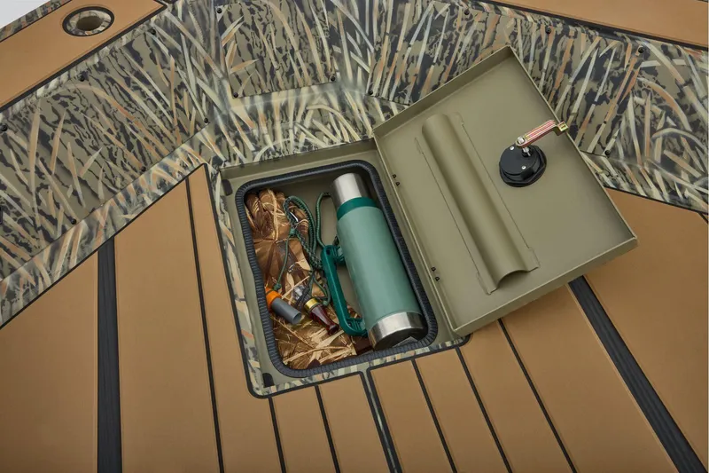 Slide: The Image of 2026 Tracker Grizzly 1756 T Marsh boat interior with open storage compartment and control panel. - 13