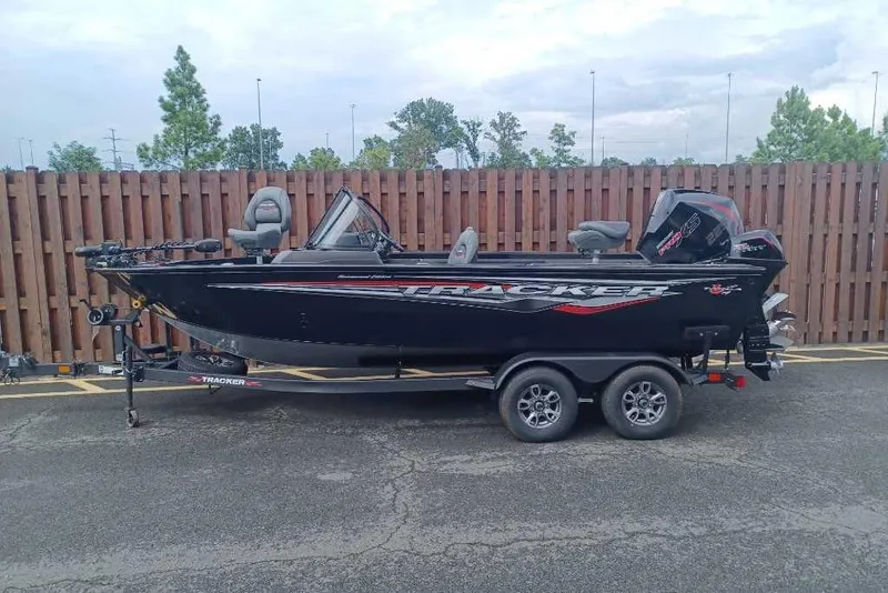 Slide: The Image of 2026 Mako 18 Pro Skiff boat on trailer, parked outdoors near wooden fence. - 52