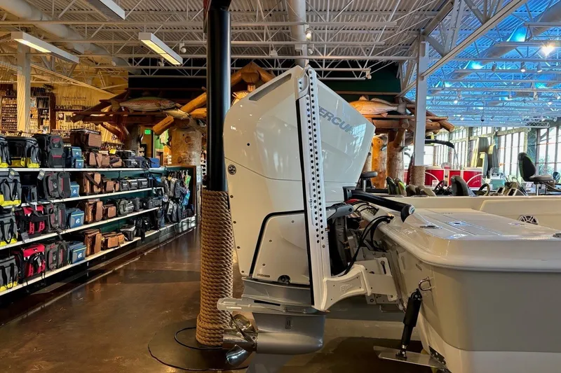 Slide: The Image of 2026 Ranger 2510 Bay boat displayed indoors, surrounded by fishing gear and equipment. - 10