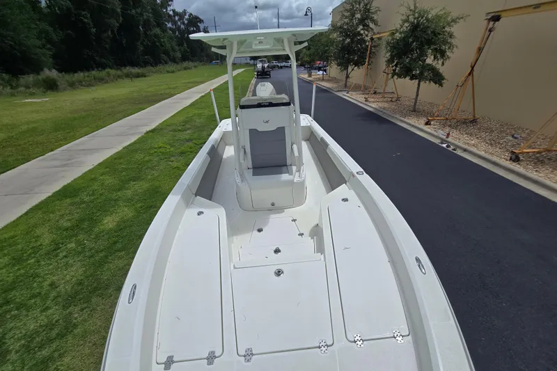 Slide: The Image of 2026 Mako 24 APEX boat on a paved road, showcasing spacious deck design. - 3