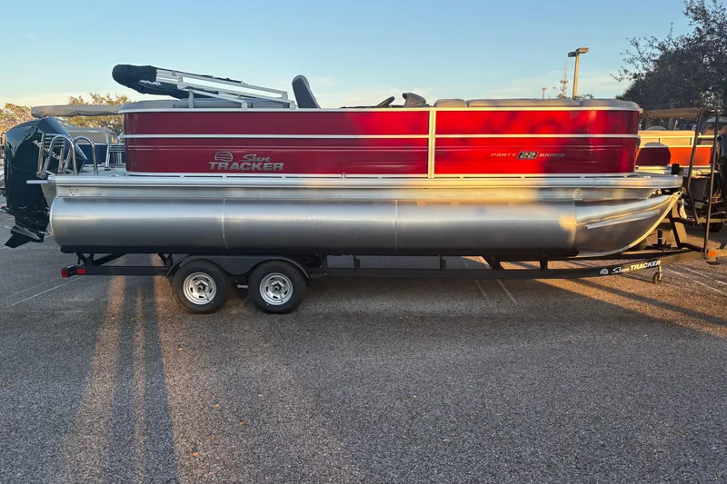 The Image of 2026 Sun Tracker Party Barge 22 XP3 pontoon boat on trailer, parked outdoors. - 0