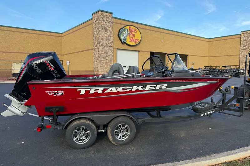 The Image of 2026 Tracker Targa V-19 Combo boat in red, parked outside Bass Pro Shops. - 1
