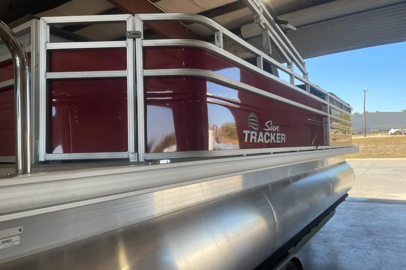 Slide: The Image of 2026 Sun Tracker SportFish 22 XP3 pontoon boat in a garage setting. - 6