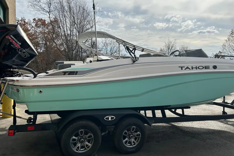 Slide: The Image of 2026 Tahoe T21 boat on trailer, light blue hull, parked outdoors. - 4