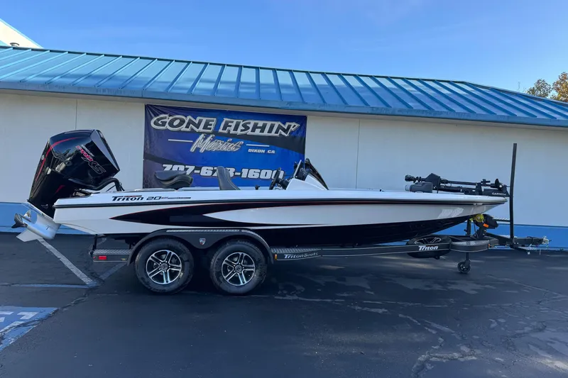 The Image of 2026 Triton 20XP Patriot boat on trailer at dealership, side view. - 0