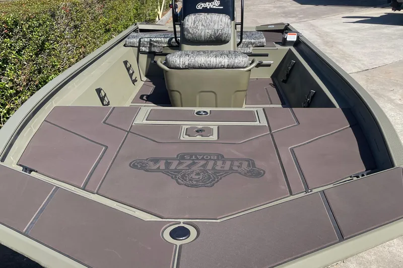 Slide: The Image of 2026 Tracker Grizzly 1860 CC boat interior with camo seats and spacious deck. - 2