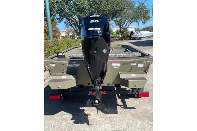 Slide: The Image of 2026 Tracker Grizzly 1860 CC boat with Mercury 90 engine, parked outdoors. - 4