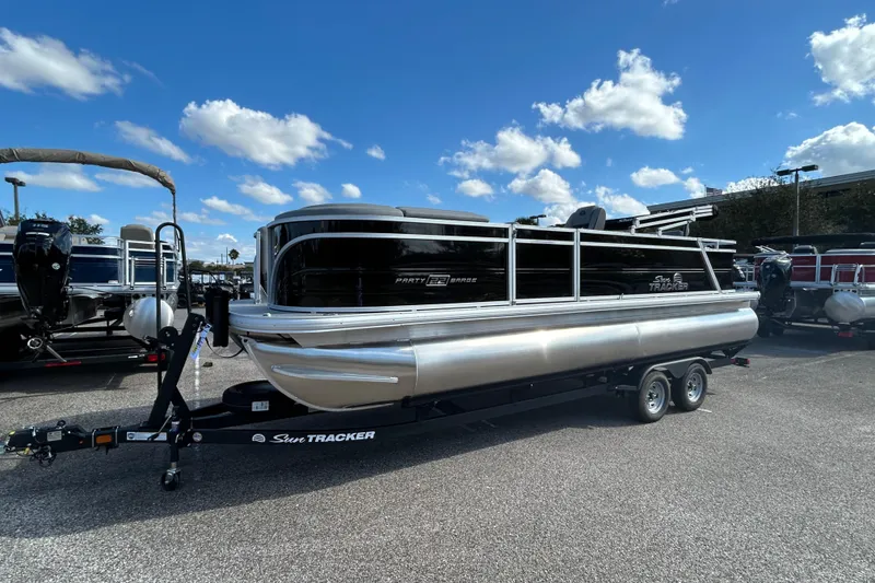 The Image of 2026 Sun Tracker Party Barge 22 RF DLX pontoon boat on trailer under blue sky. - 0