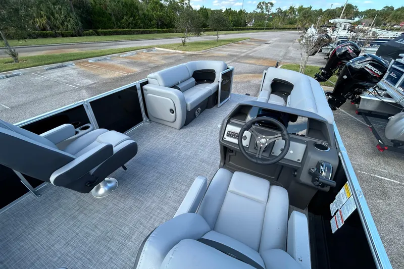 Slide: The Image of 2026 Sun Tracker Party Barge 22 RF DLX interior with seating and steering console. - 4