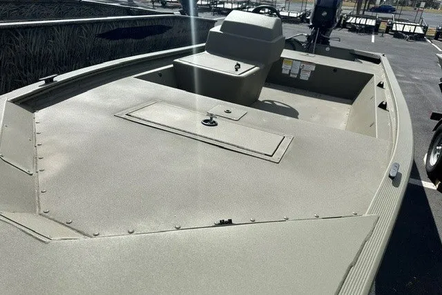 Slide: The Image of 2026 Tracker Grizzly 1648 SC boat with spacious deck and seating in a parking lot. - 5