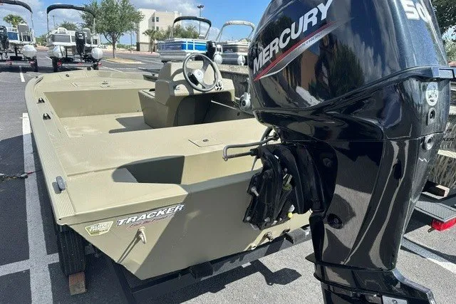 The Image of 2026 Tracker Grizzly 1648 SC boat with Mercury outboard motor in a parking lot. - 0