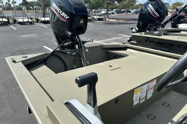 Slide: The Image of 2026 Tracker Grizzly 1648 SC boat with Mercury engine in a parking lot. - 10