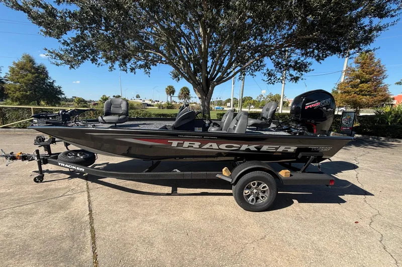 The Image of 2026 Tracker Pro Team 195 boat on trailer, parked outdoors under a tree. - 0