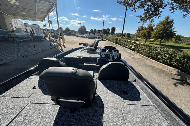 Slide: The Image of 2026 Tracker Pro Team 195 boat with dual seats and steering wheel, parked outdoors. - 2