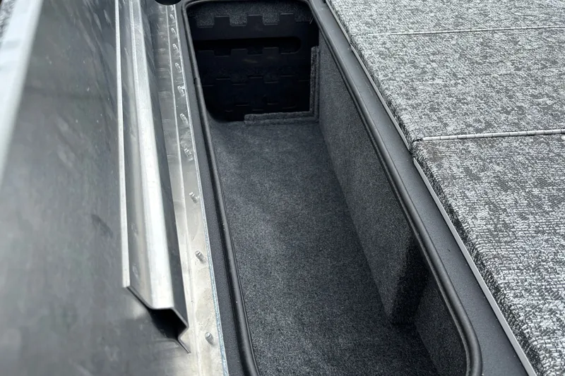 Slide: The Image of Storage compartment in 2026 Tracker Pro Team 195 boat, featuring carpeted interior and metal frame. - 20