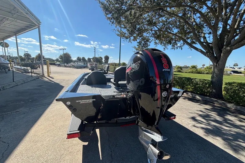Slide: The Image of 2026 Tracker Pro Team 195 boat with powerful 150 HP engine, parked outdoors. - 3