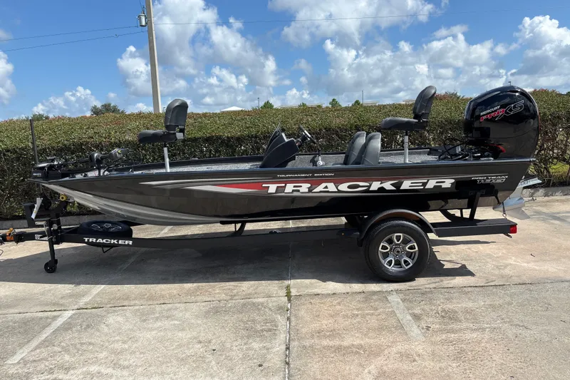 The Image of 2026 Tracker Pro Team 195 boat on trailer, parked outdoors under a blue sky. - 0