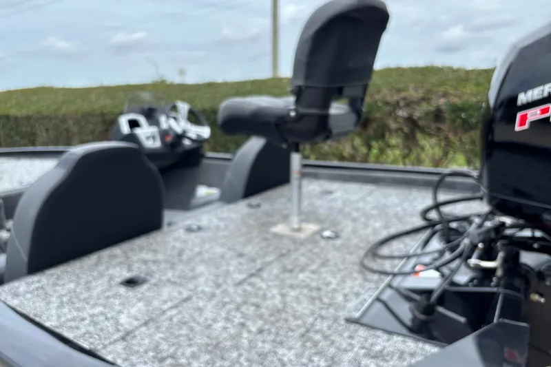 Slide: The Image of 2026 Tracker Pro Team 195 boat interior with seating and motor, outdoors. - 29