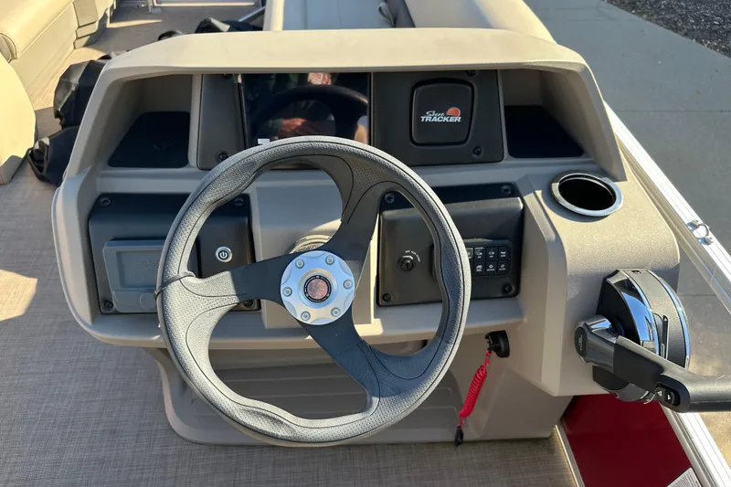Slide: The Image of 2024 Sun Tracker Party Barge 18 DLX steering console with controls and cup holder. - 5