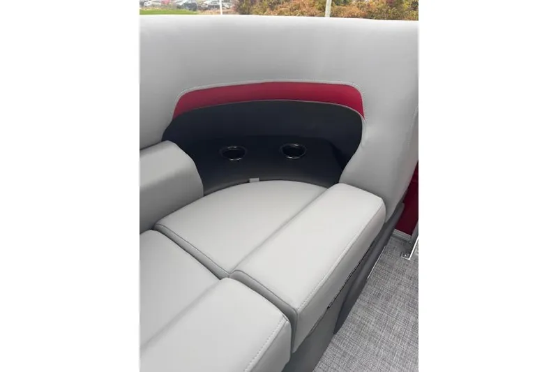 Slide: The Image of 2026 Sun Tracker Party Barge 22 DLX interior seating with cup holders, gray and red upholstery. - 11