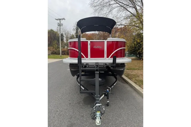 Slide: The Image of 2026 Sun Tracker Party Barge 22 DLX pontoon boat on trailer, parked on a road. - 2