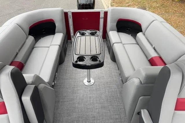 Slide: The Image of 2026 Sun Tracker Party Barge 22 DLX interior with gray and red seating, central table. - 6