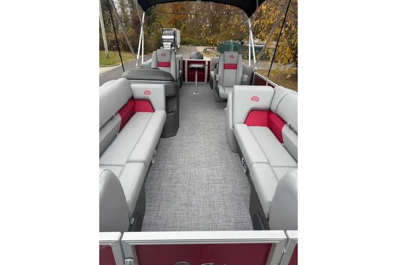 Slide: The Image of 2026 Sun Tracker Party Barge 22 DLX interior with gray and red seating, outdoor setting. - 8
