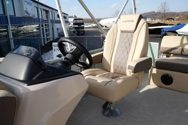 Slide: The Image of 2026 Harris Cruiser 230 boat interior with captain's chair and steering console. - 13