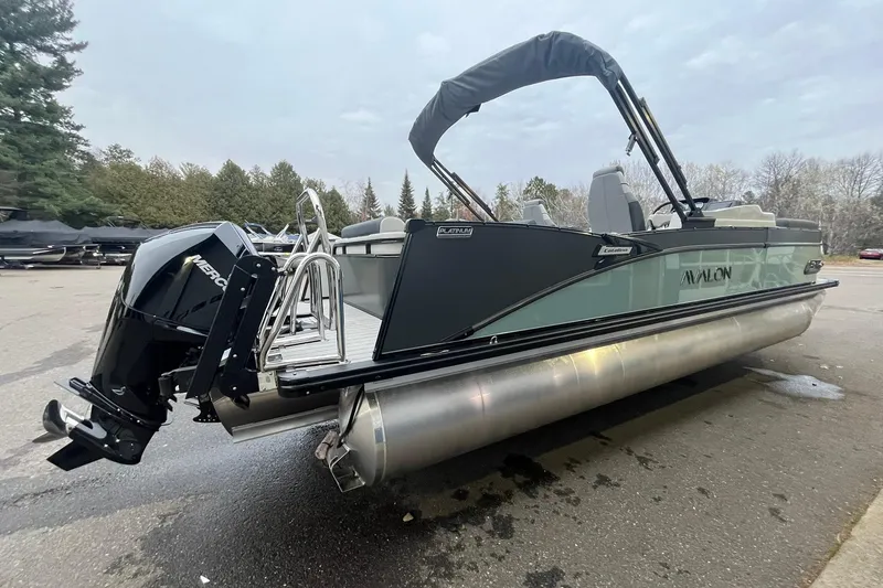 Slide: The Image of 2026 Avalon Catalina Versatile Rear Lounger pontoon boat with Mercury engine, parked outdoors. - 4
