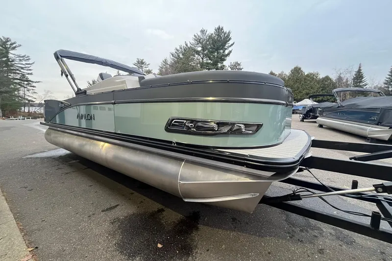 Slide: The Image of 2026 Avalon Catalina Versatile Rear Lounger pontoon boat on trailer, parked outdoors. - 5