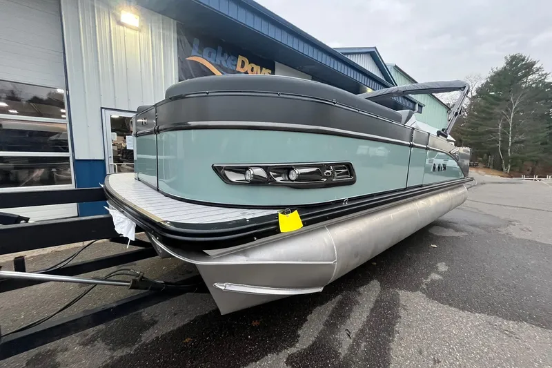 Slide: The Image of 2026 Avalon Catalina Versatile Rear Lounger pontoon boat parked outside a building. - 7