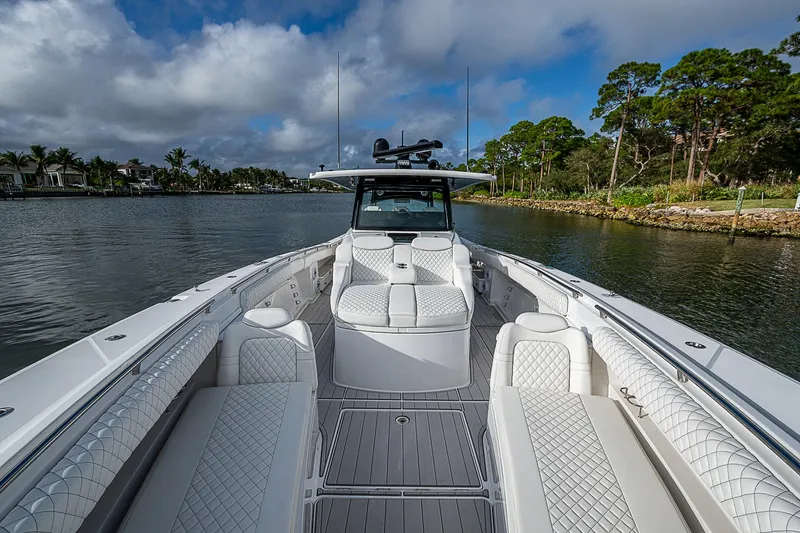 Slide: The Image of 2023 HCB 53 Sueños boat on a scenic waterway with lush greenery. - 5