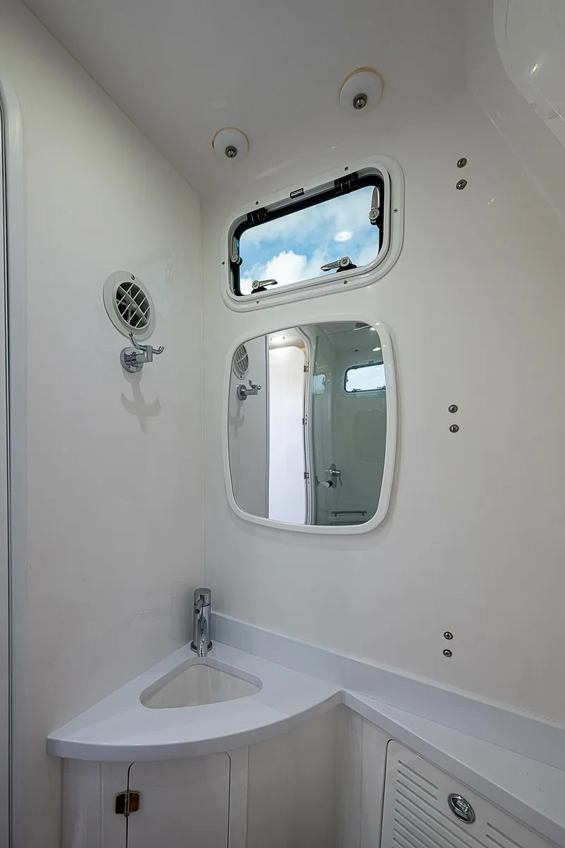 Slide: The Image of 2023 HCB 53 Sueños boat bathroom with modern fixtures and a small window. - 8