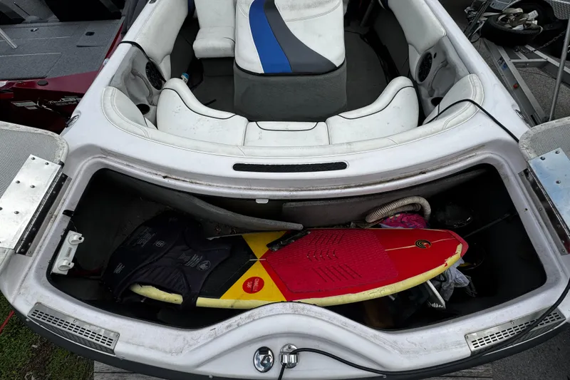 Slide: The Image of 2004 Nautique Air Nautique 216 boat interior with storage compartment and surfboard. - 3