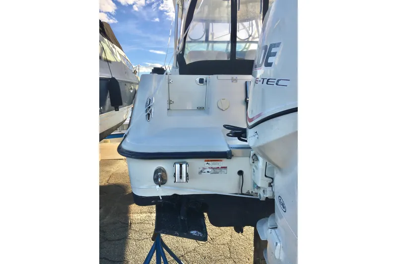 Slide: The Image of 2006 Hydra-Sports Vector 2900 VX boat stern with E-TEC engine, docked under clear sky. - 10