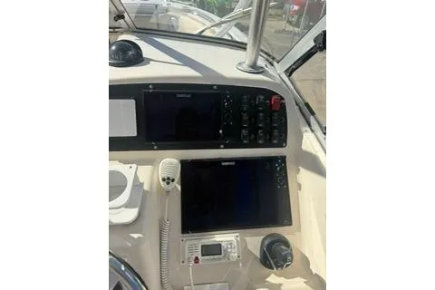 Slide: The Image of 2011 Grady-White Freedom 275 boat dashboard with navigation controls and radio. - 14