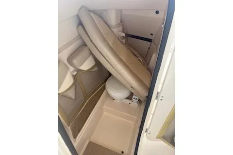 Slide: The Image of 2011 Grady-White Freedom 275 boat interior with compact toilet and beige seating. - 19
