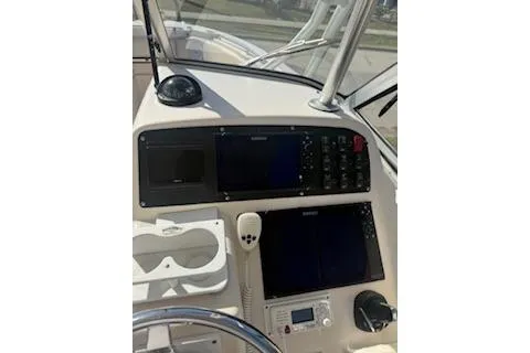 Slide: The Image of 2011 Grady-White Freedom 275 boat dashboard with navigation controls and steering wheel. - 21
